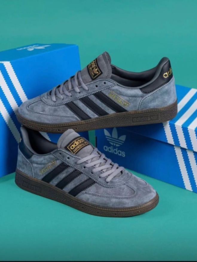 Adidas Handball Spezial sneakers feature a grey suede upper and dark gum sole.